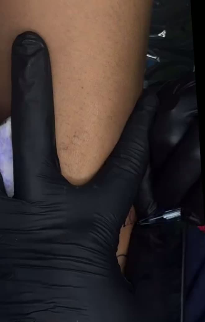 Gloved hands lining a tattoo at Balu Ink Tattoos